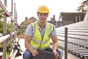 A roofer sits on a roof