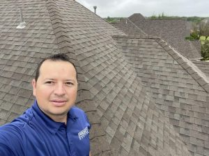 A man takes a selfie on a shingled roof
