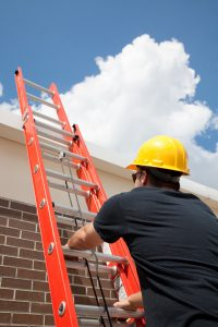 A worker climbs a ladder