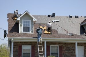 Roofers work on a residential roof