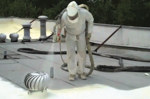 A roofer uses spray foam on a commercial roof