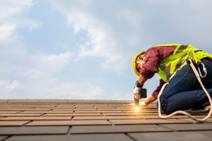 A worker repairs a roof
