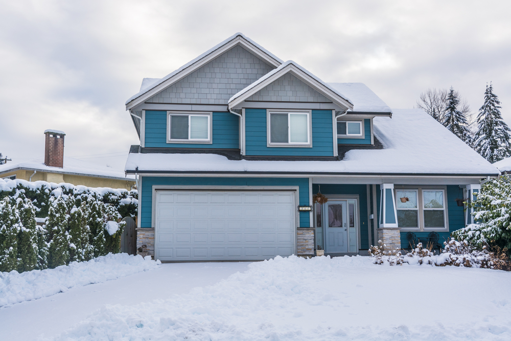 A blue home covered in snow